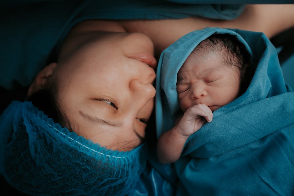 mother holding newborn baby bonding skin contact warm