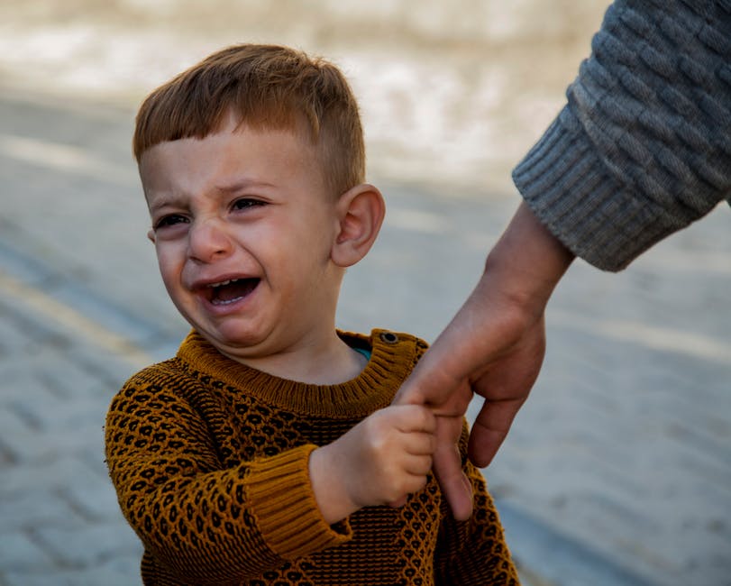 child crying at school gate, parent comforting child separation anxiety
