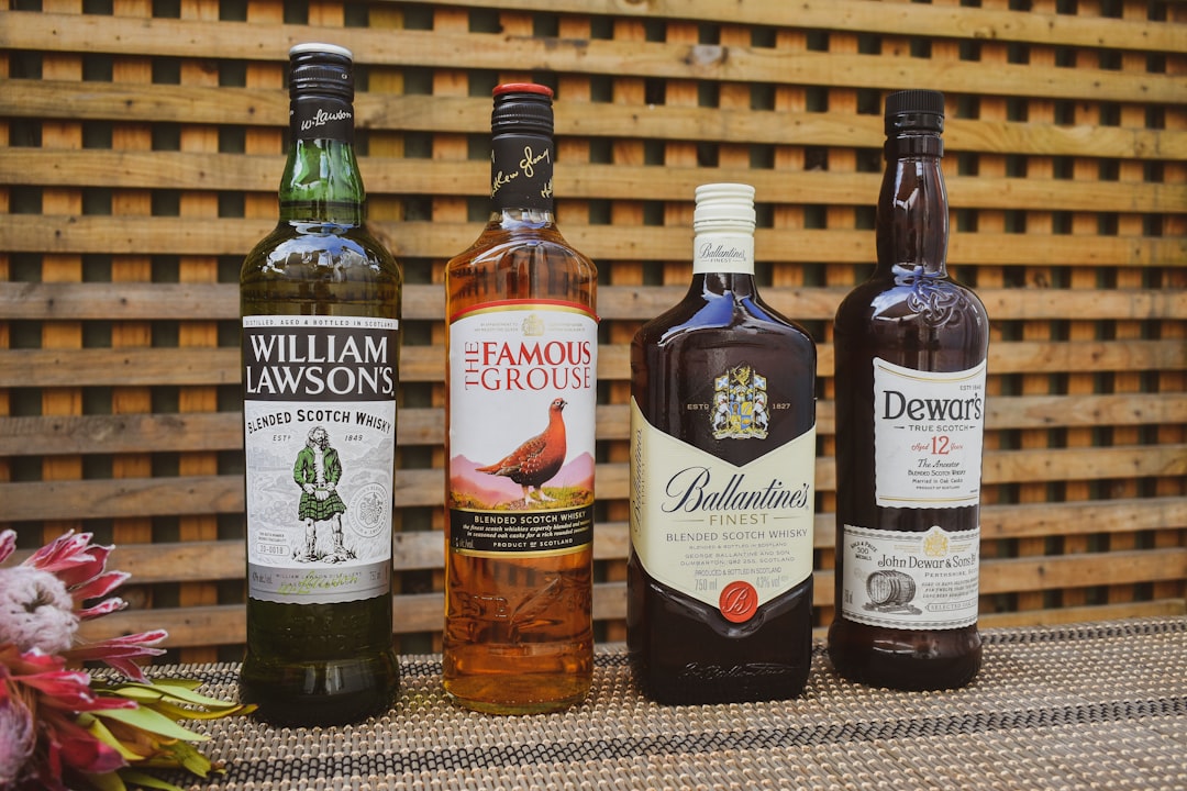 single malt whisky bottles lineup, scotch whisky glass amber light